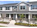 Charming townhome with stone accents, light blue shutters, and a covered front porch with white railings at 1317 Coral Bean Ln, Winter Springs, FL 32708