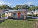 Tan mid-century home with a carport and a spacious yard at 1514 Doreen Ave, Ocoee, FL 34761