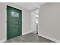 Modern entryway featuring a dark green door and gray flooring at 204 Louis St, Leesburg, FL 34748