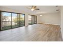 Bright living room with laminate wood flooring, ceiling fan, and sliding glass doors to the balcony at 230 Moree Loop # 4, Winter Springs, FL 32708