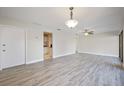 Open-concept living room and kitchen with new gray laminate flooring, ceiling fan, and bright lighting at 230 Moree Loop # 4, Winter Springs, FL 32708