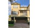 Front view of a three-story townhome with a brown garage door and balcony at 2586 Grand Central Pkwy # 1, Orlando, FL 32839