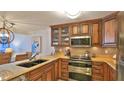 Kitchen featuring custom wood cabinets, stainless steel appliances, and tile backsplash at 4175 S Atlantic Ave # 232, New Smyrna Beach, FL 32169