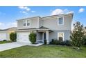 Charming two-story home with a two car garage and manicured lawn on a sunny day at 514 Eagle Landing Blvd, Winter Haven, FL 33880
