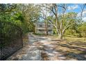 Long driveway leads to the charming two-story home with a welcoming front porch, set amongst mature trees at 632 Tildenville School Rd, Winter Garden, FL 34787