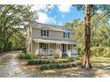 Charming two-story home with a welcoming front porch, lush landscaping, and a tranquil setting at 632 Tildenville School Rd, Winter Garden, FL 34787