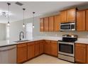 Kitchen featuring stainless steel appliances, wooden cabinetry, and white countertops at 8008 Page Ct, Haines City, FL 33844