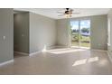 Bright living room with tile flooring, fan, and a sliding glass door to the backyard at 8008 Page Ct, Haines City, FL 33844