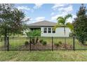 The home's backyard has tropical trees and a black metal fence at 13557 Parkfield Way, Winter Garden, FL 34787