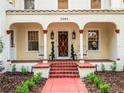 Inviting front porch with decorative columns, a brick walkway, and traditional rocking chairs at 2004 Magnolia Ave, Sanford, FL 32771