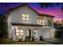 Charming two-story home featuring a tile roof, balcony, arched entryway, and a well-manicured front yard at 2309 Depauw Ave, Orlando, FL 32804