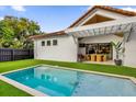 Inviting swimming pool in backyard with artificial turf and patio furniture at 2309 Depauw Ave, Orlando, FL 32804