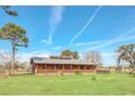 Ranch style home with metal roof, large porch, and fenced yard at 26225 Pitts Rd, Eustis, FL 32736