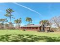 Ranch style home with metal roof, large porch, and fenced yard at 26225 Pitts Rd, Eustis, FL 32736