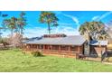 Ranch style home with metal roof, large porch, and fenced yard at 26225 Pitts Rd, Eustis, FL 32736