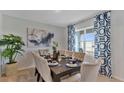 Dining room with a dark wood table, neutral chairs, and blue patterned curtains at 33463 Copper Hill Way, Sorrento, FL 32776
