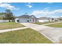 Single story home with gray siding, red door, and attached garage; view of neighborhood at 3450 Clingman St, Deltona, FL 32738