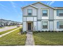 Front view of a two-story townhome with a dark brown door and brick walkway at 3798 Lana Ave, Davenport, FL 33897