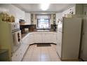 Bright kitchen features white appliances, tiled flooring, granite countertops and natural light through a window at 423 Longfellow Blvd, Lakeland, FL 33801