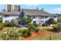 Exterior view of condo building, showcasing landscaping and nearby high-rise buildings at 4411 Sea Mist Ct # 174, New Smyrna Beach, FL 32169