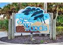 Sea Woods entrance sign featuring a coastal theme with palm trees and beach elements at 4411 Sea Mist Ct # 174, New Smyrna Beach, FL 32169