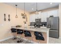 Modern kitchen featuring stainless steel appliances, a breakfast bar, and stylish pendant lighting at 4800 Memories Ln, Kissimmee, FL 34746