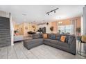 Spacious living room with tile flooring, comfortable seating, breakfast bar, and staircase access at 4800 Memories Ln, Kissimmee, FL 34746