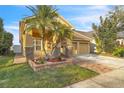 Well-maintained home featuring a two-car garage, manicured lawn, and vibrant tropical landscaping at 4912 Atwood Dr, Orlando, FL 32828