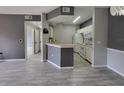Open living space with modern flooring, neutral paint, and a view into the kitchen at 5518 Metrowest Blvd # 104, Orlando, FL 32811