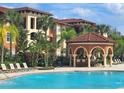 Community pool with gazebo and lounge chairs, surrounded by lush tropical landscaping at 5518 Metrowest Blvd # 104, Orlando, FL 32811
