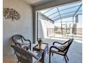 An outdoor patio with comfortable seating, a table, and a screened pool enclosure for relaxation at 9023 Dogleg Dr, Davenport, FL 33896