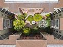 Aerial view of the courtyard featuring lush landscaping, mature palm trees, and a central water feature at 911 N Orange Ave # 352, Orlando, FL 32801