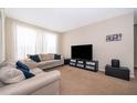 Living room with beige couches and a large TV at 9141 Lee Vista Blvd # 305, Orlando, FL 32829