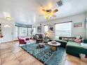 Inviting living room with large windows, a plush rug, and comfortable green sofa with colorful pillows at 9263 Lake Lotta Cir, Gotha, FL 34734
