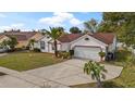Well-kept single Gathering home with an attached two car garage, mature landscaping, and a concrete driveway at 9664 Lake Douglas Pl, Orlando, FL 32817