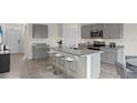 Modern kitchen with gray cabinets, granite countertops, and an island at 1277 Limbali St, Mount Dora, FL 32757