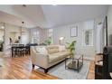 Bright living room featuring wood floors, a neutral sofa, and dining area at 1341 Arbor Vista Loop # 321, Lake Mary, FL 32746
