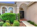Front entry with double doors and manicured landscaping at 14872 Faversham Cir, Orlando, FL 32826
