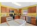 Functional kitchen with wooden cabinets, modern appliances, and a cozy breakfast table with tile accents at 2029 Knollcrest Dr, Clermont, FL 34711