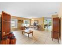 Open-concept living room with tile floors, large windows and seamless flow to dining area at 2029 Knollcrest Dr, Clermont, FL 34711