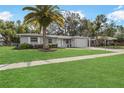 Charming single-story home with a well-manicured lawn and a beautiful mature palm tree at 2049 Jefferson Ave, Deltona, FL 32738