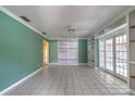 Spacious and airy living room featuring tile floors, built-in shelving, and glass doors leading to the outdoors at 2460 Worthington Rd, Maitland, FL 32751