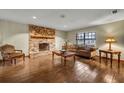 Living room with stone fireplace, wood floors, and comfy furniture at 2770 Windsong Ln, St Cloud, FL 34772