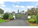 Sprawling ranch home featuring a gated entry, mature landscaping, and freshly manicured lawn at 4154 Equestrian Ln, Windermere, FL 34786