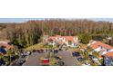 Aerial view of a townhome complex with a tile roof, reserved parking, and mature landscaping at 4765 Capri Pl # 209, Orlando, FL 32811