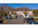 Two-story townhome with a tile roof, decorative windows, reserved parking, and mature landscaping at 4765 Capri Pl # 209, Orlando, FL 32811