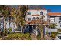 Charming townhome featuring a tile roof, decorative windows and gate, and mature landscaping at 4765 Capri Pl # 209, Orlando, FL 32811