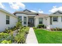 Close up of front entrance with double doors, elegant landscaping, and walkway at 530 Sanctuary Blvd, Winter Haven, FL 33881