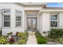 Inviting front entrance with decorative glass doors and lush landscaping at 530 Sanctuary Blvd, Winter Haven, FL 33881