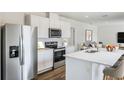 Modern kitchen with white cabinets, stainless steel appliances, and island at 5626 Paddock Fence Ln, Apopka, FL 32712